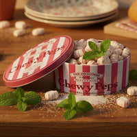 An open round tin of The Original Chewy Peps candy sits on a white studio background with several individual candy pieces placed in front. The tin has red and white vertical stripes and the lid shows the product name clearly.